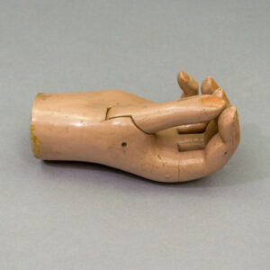 Antique articulated mechanical prosthetic right hand, flesh-toned enamel, with jointed fingers in open grip position.