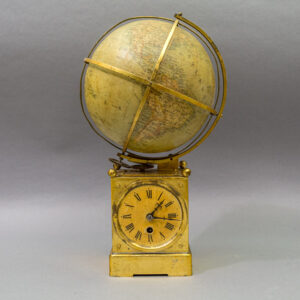 Antique terrestrial globe, circa 1900, mounted atop a patinated brass mechanical clock base featuring a Roman numeral dial, exposed gearing, and encompassing brass meridian and equatorial rings.
