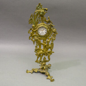 Allegorical Brass Victorian Watch Hutch, Rococo Revival. Scrolling acanthus ornament, figural putti amid asymmetrical C-scrolls and naturalistic motifs